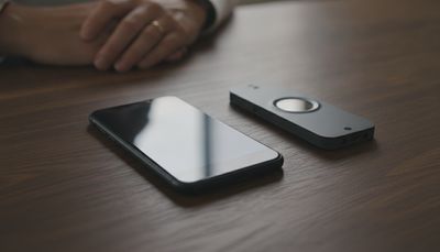 Zwei Smartphones liegen nebeneinander auf einem dunklen Tisch im gedämpften Licht
